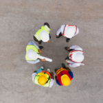 Manufacturing plant manager reviewing an execution plan with operational leaders at a production floor conference table