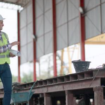 Plant supervisor and floor lead reviewing a practical fix at a production workstation in a small manufacturing facility