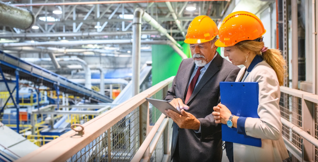 Plant manager reviewing equipment plans on an industrial manufacturing floor
