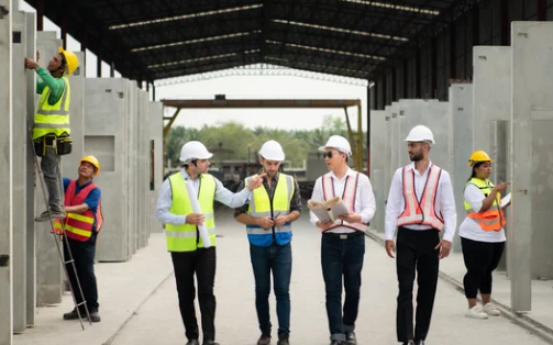 Production supervisor leading a shift huddle as an example of mid-level leadership in manufacturing